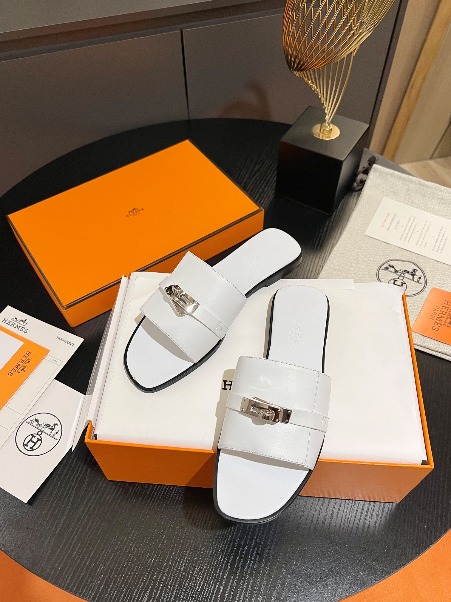 971b4813c5adc8b9f07cc8422eec471e.png Hermès Classic Kelly Buckle Slides – Summer Essential (White )